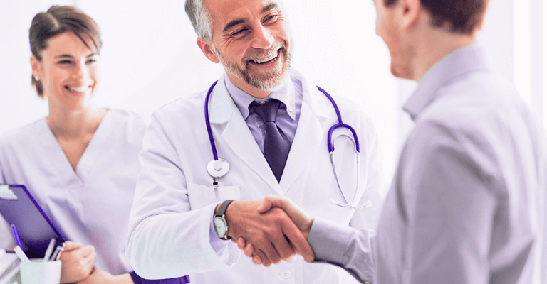 Imagem de um médico do Americas Serviços Médicos sorrindo e apertando a mão de outro homem.