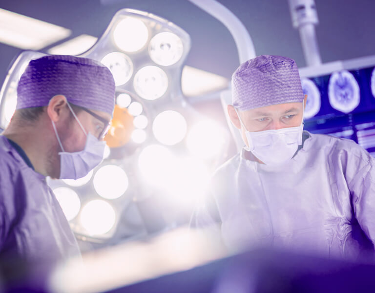Imagem com dois médicos em sala de cirurgia robótica